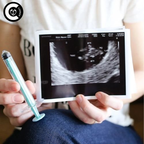 A woman showing an ultrasound report while using an at-home insemination kit