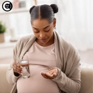 Pregnant woman holding progesterone supplement bottle with hopeful expression