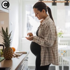 Serene pregnant woman smiling, holding prenatal vitamins with fresh fruits